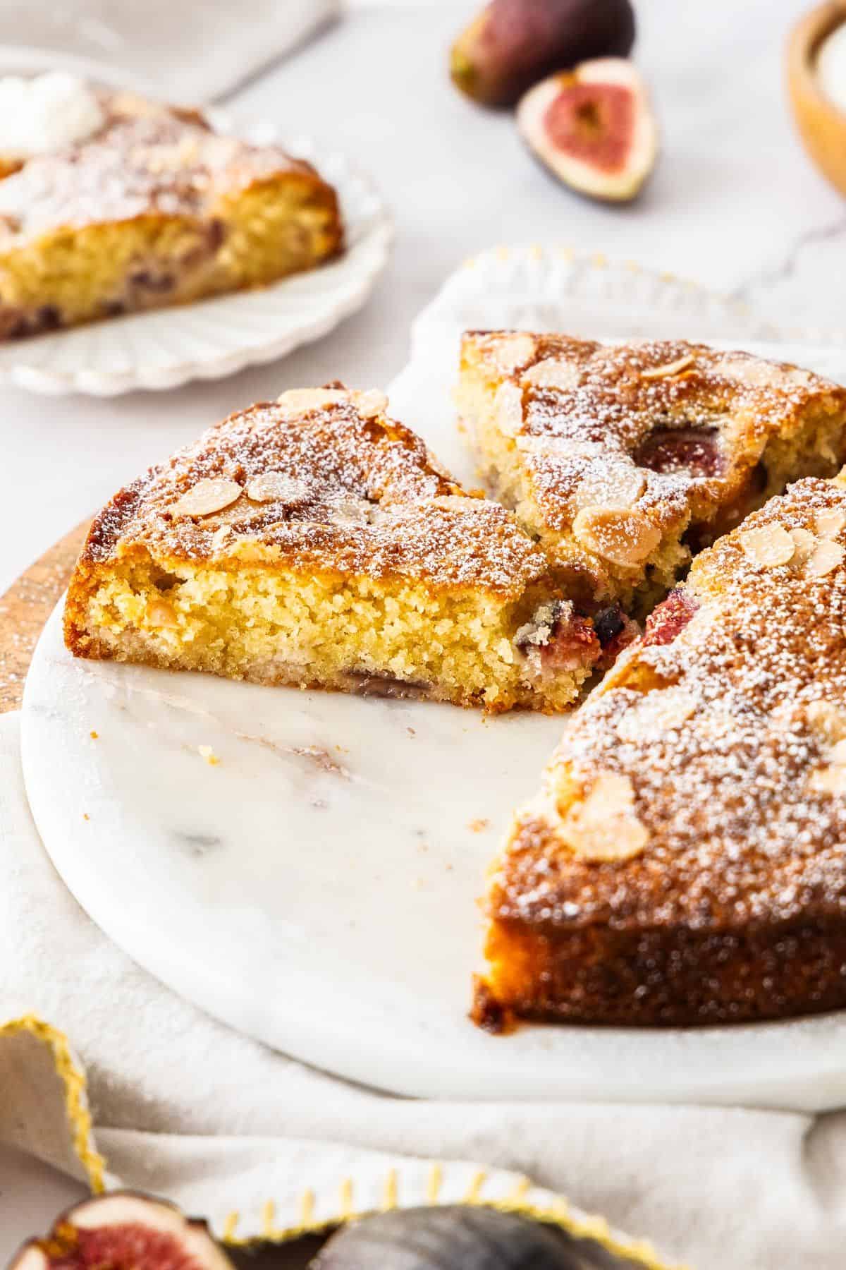Gluten-Free Fig Cake on a white platter, with some slices removed.