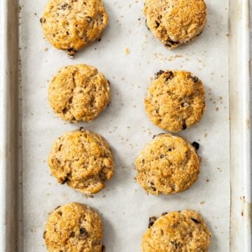 Freshly baked Sultana Scones stacked on some baking paper.