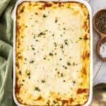 White rectangular dish of Mediterranean Sausage Pasta Bake, topped with a sprinkling of fresh parsley.