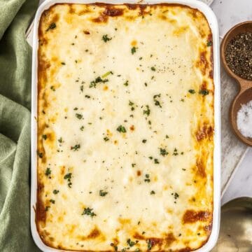 White rectangular dish of Mediterranean Sausage Pasta Bake, topped with a sprinkling of fresh parsley.