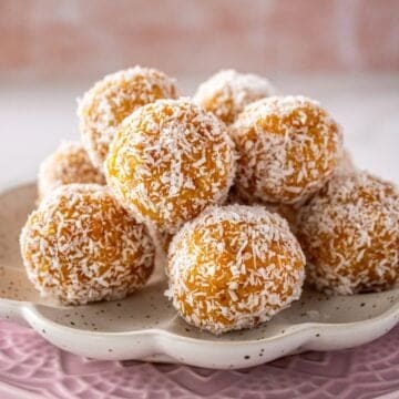 Two plates, one pink and one white, with a pile of Peach Bliss Balls on top.