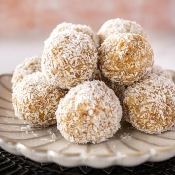 Two plates, one black and one white, with a pile of Pear Bliss Balls on top.